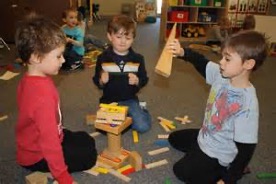 children sitting on the floor playing with building blocks