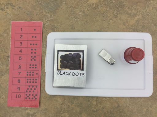 red card with numbers and tray of black dots