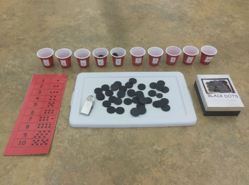 tray of black dots with red score card and small red cups