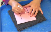 child hand following along the letter H to draw letter