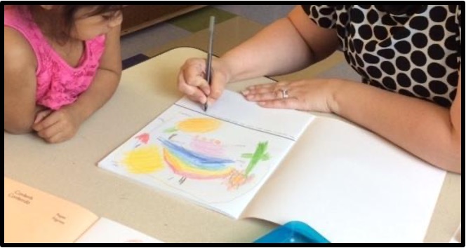 teacher writing in a notebook while child watches