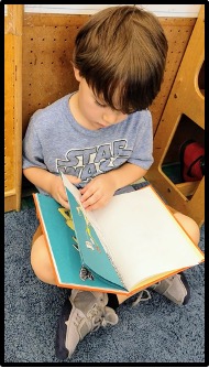 child turning page in book