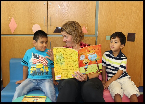 teacher reading to two students