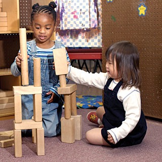 two children build blocks together