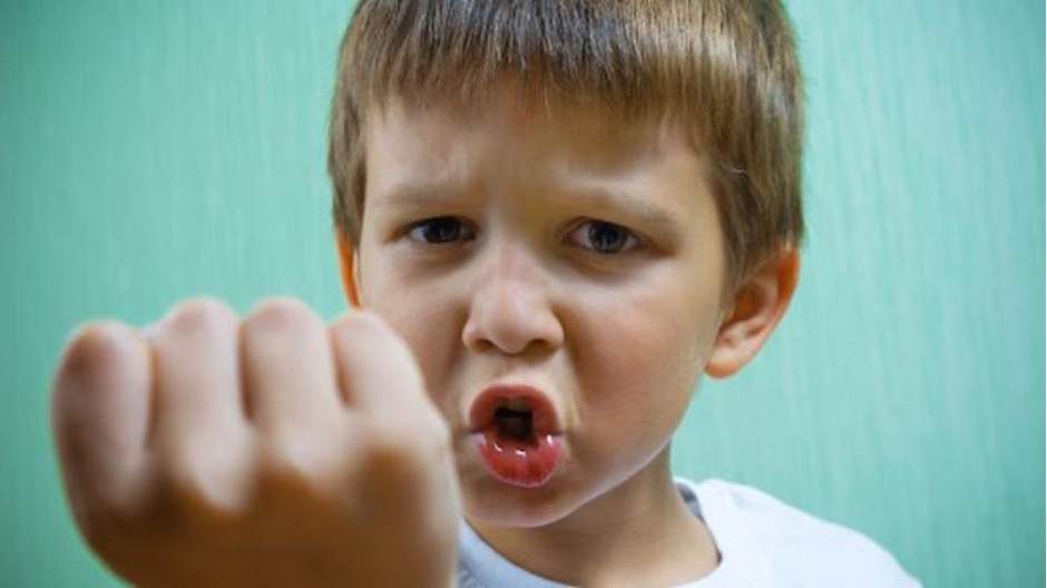 child with angry face and fist