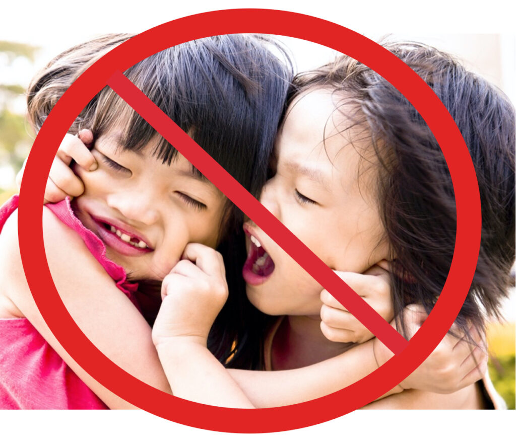 Two girls pinching each other's cheeks in anger.