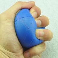 A hand squeezing a small soft ball.