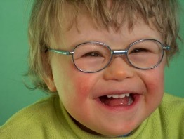 A boy with glasses  laughing.