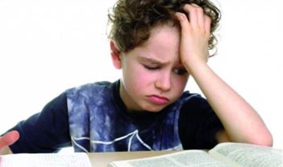 Boy with hand on his head appearing upset and pouting.