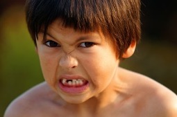 Boy angry with teeth barred.