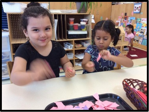 Two children tearing paper