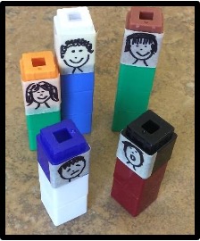  Five small Unifix towers with tape attached and faces drawn with a marker