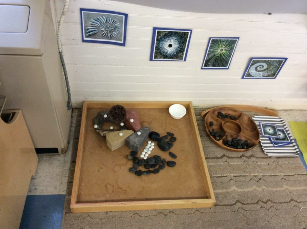 Sensory sand an stones activity for one child on the floor. 