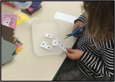 Child cutting up their name strip