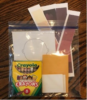 Small kit or materials with multicultural crayons, shades of brown color swatch strips, small squares of white oaktag, 2 small envelopes, stack of blank face outline-templates.
