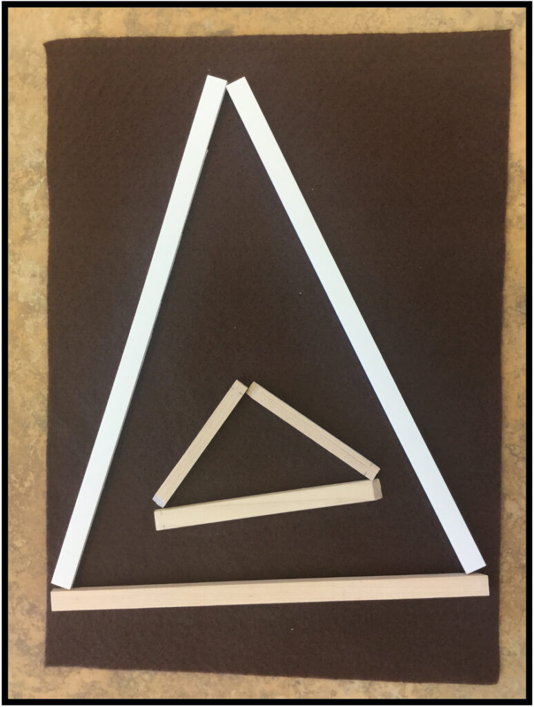 large wood piece triangle with small wood piece triangle inside