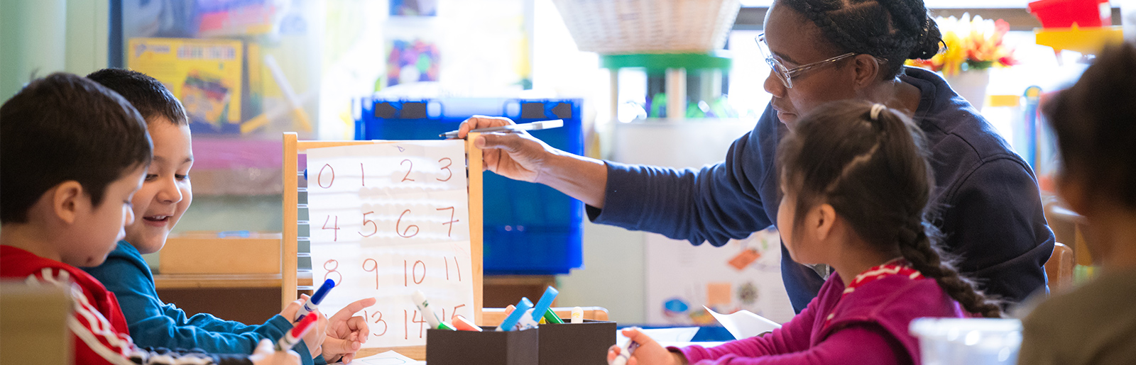 Teacher showing numbers to children