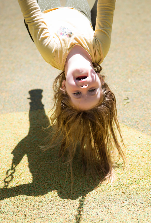 child upside down on a swing