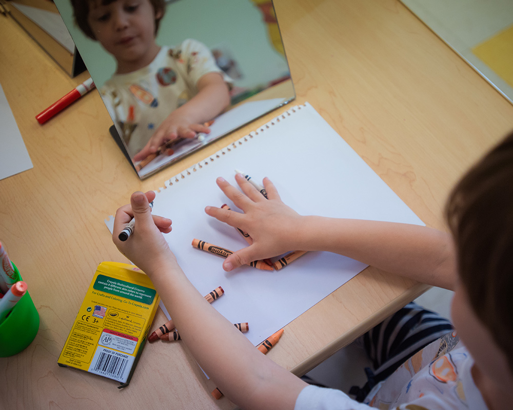 child pointing to color on paper